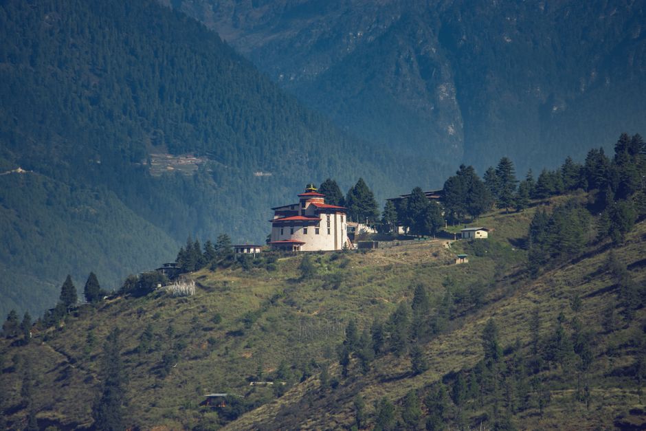 A distant view of Paro Taktsang Monastery nestled in the lush mountains of Bhutan.