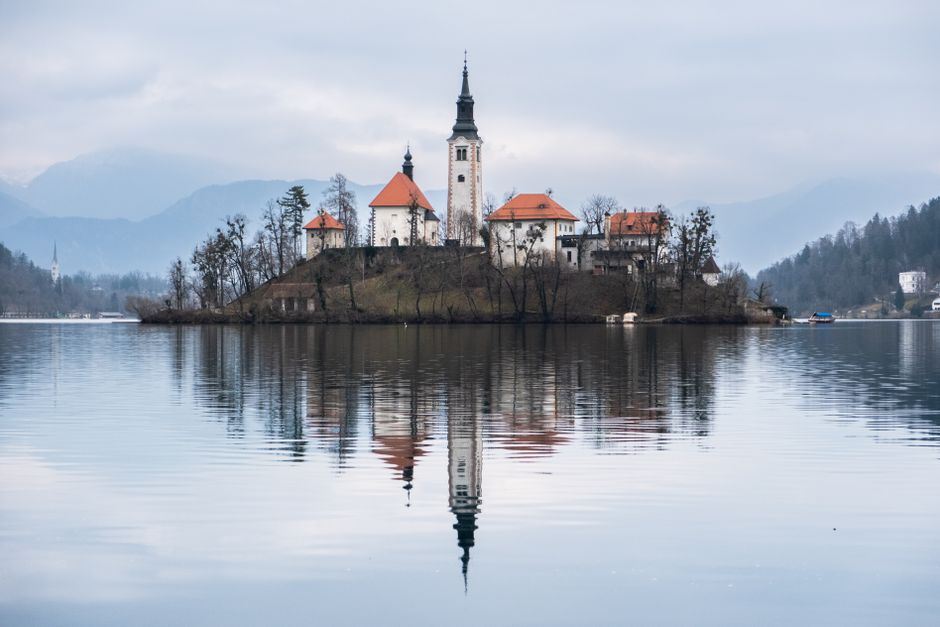 A serene view of Bled Island with church reflecting on Lake Bled in Slovenia.