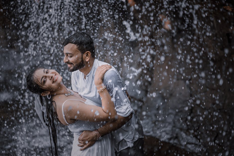 A joyful couple embracing under a cascading waterfall, expressing love and happiness.