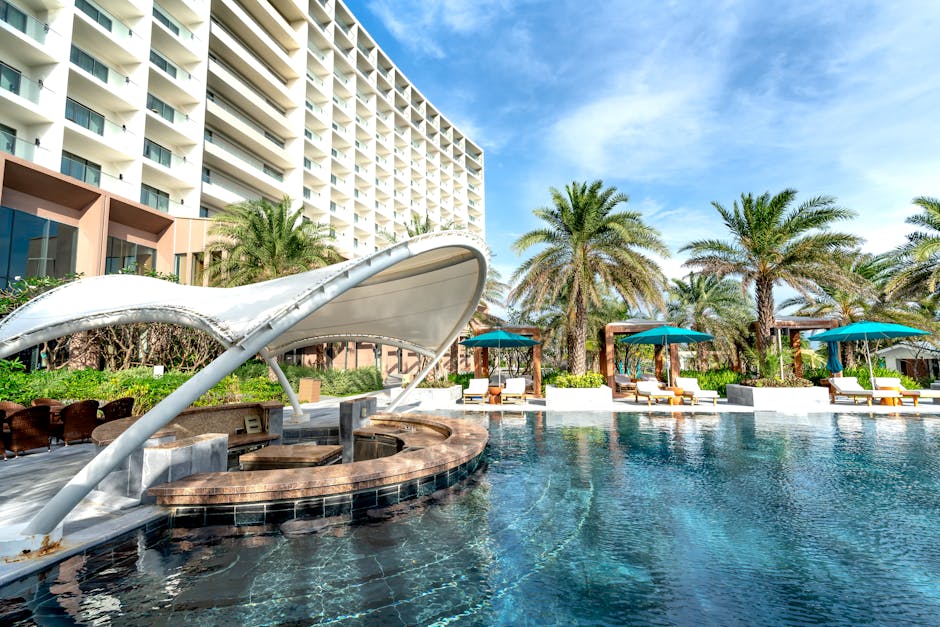 Stunning view of a luxury resort with poolside cabanas, palm trees, and modern architecture.