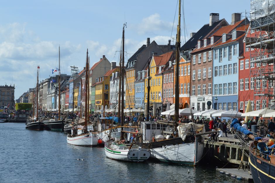 Vibrant waterfront scene of Nyhavn harbor with historic buildings and boats in Copenhagen.