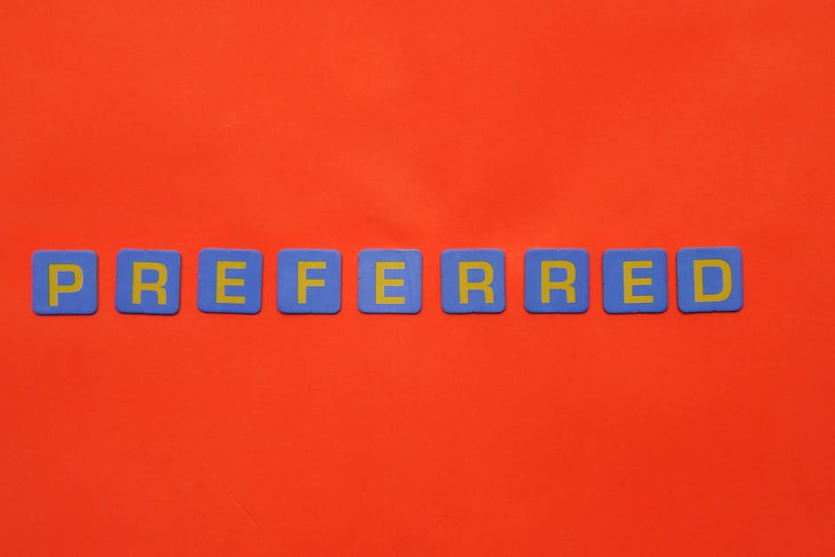 Blue and yellow letters spelling 'preferred' on a vibrant red surface with copy space.