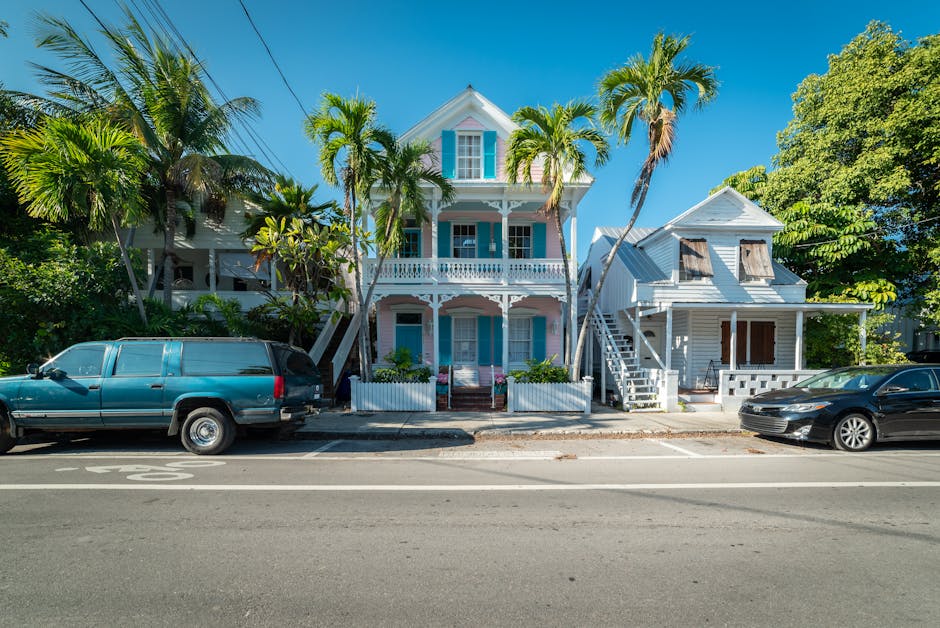 Colorful historic houses with palm trees along a sunny street in Key West, Florida.